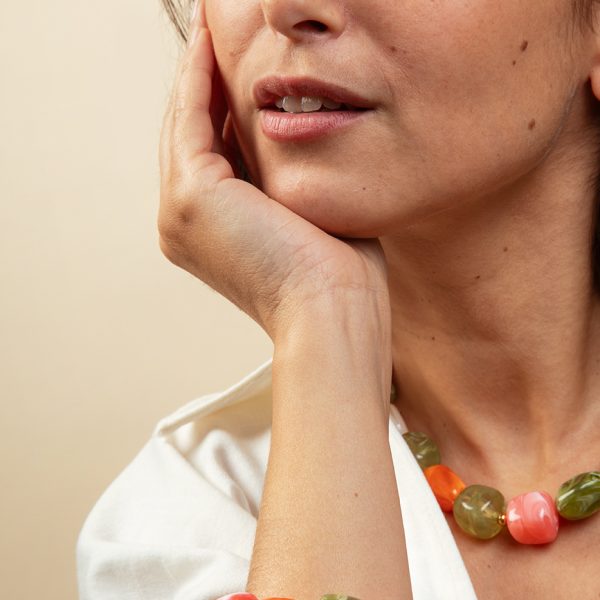 Femme portant un bracelet de perles colorées en galets acryliques nacrés corail et vert olive, bijoux artisanaux collection Riviera Mademoiselle Nuage